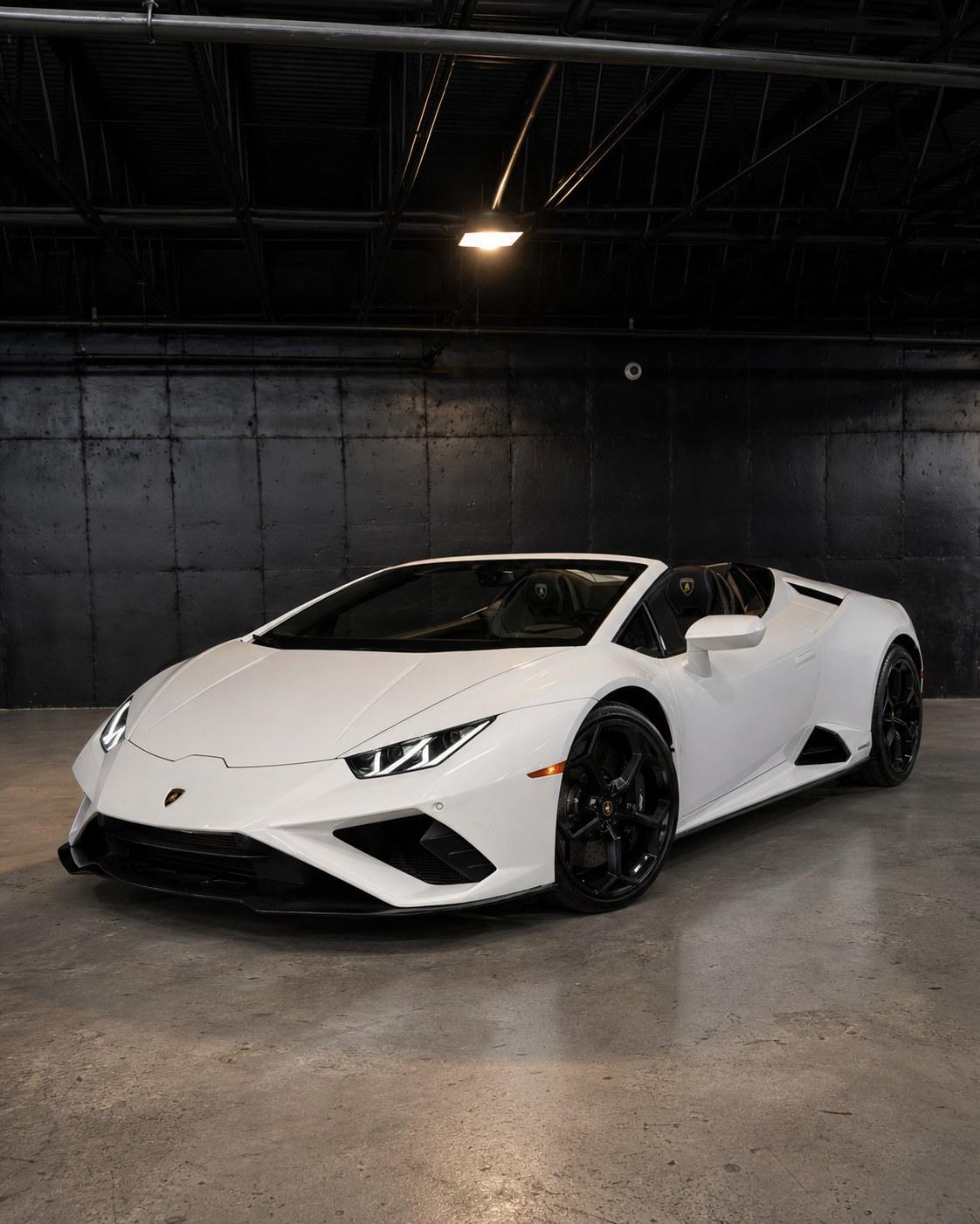 White 2024 Lamborghini Huracan EVO Spyder with the top down, front three quarter in a dark studio