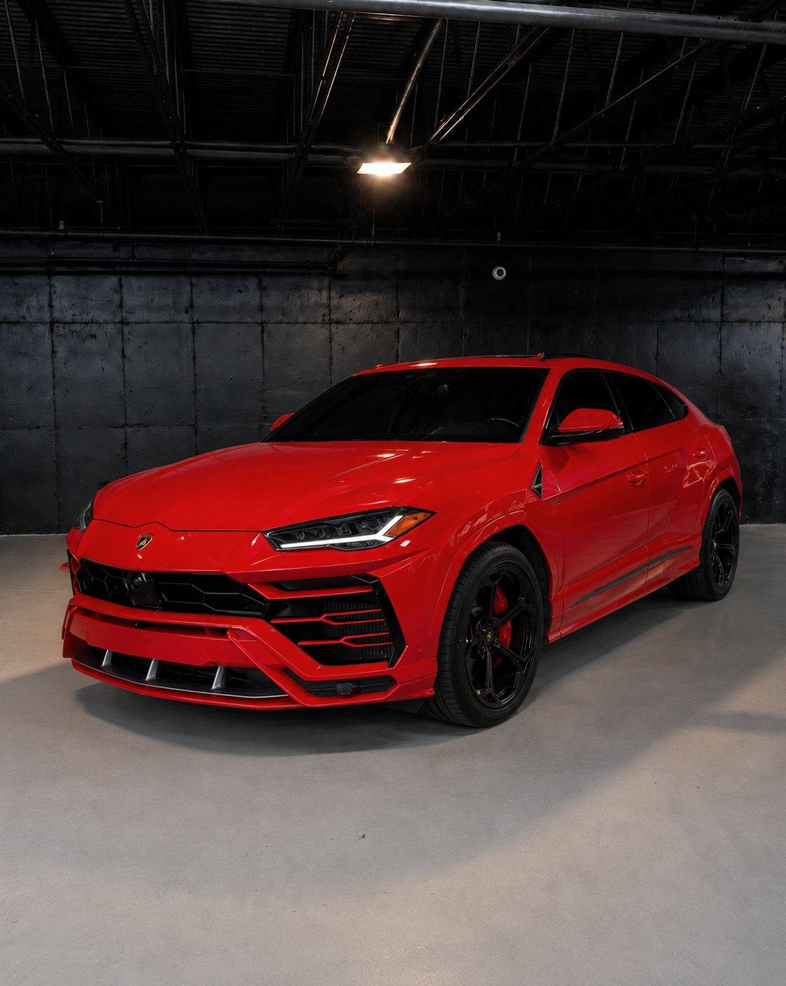 Red Lamborghini Urus, front three quarter in a dark studio