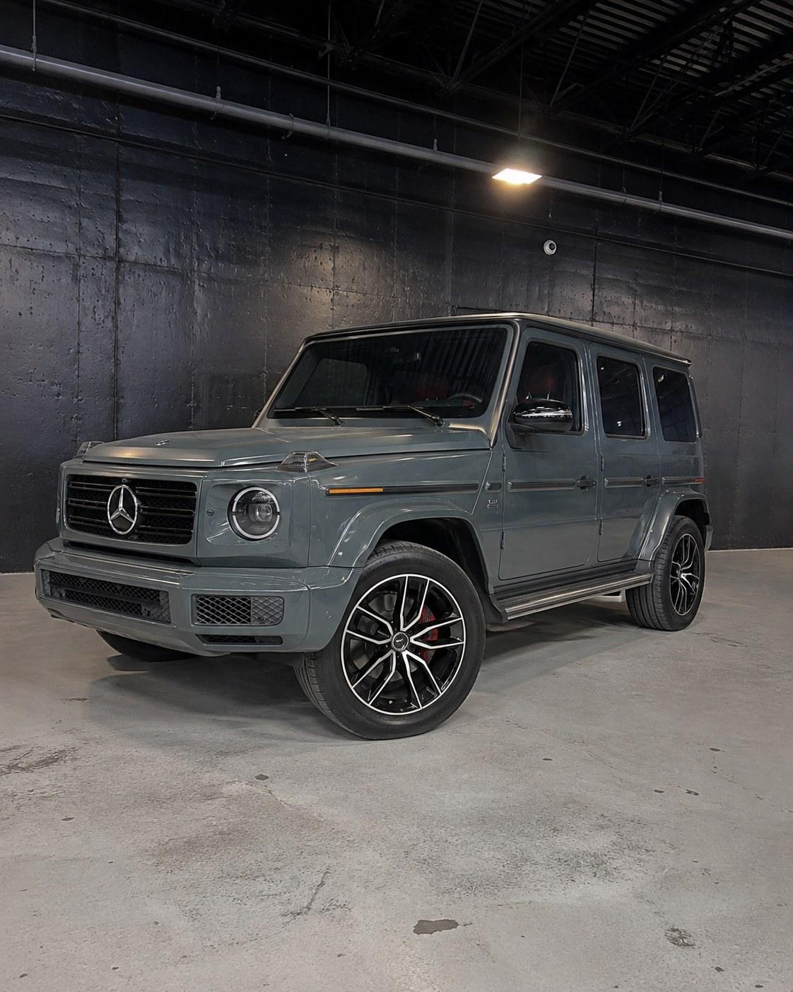 Grey Mercedes-AMG G63 with red interior, front three quarter in a dark studio