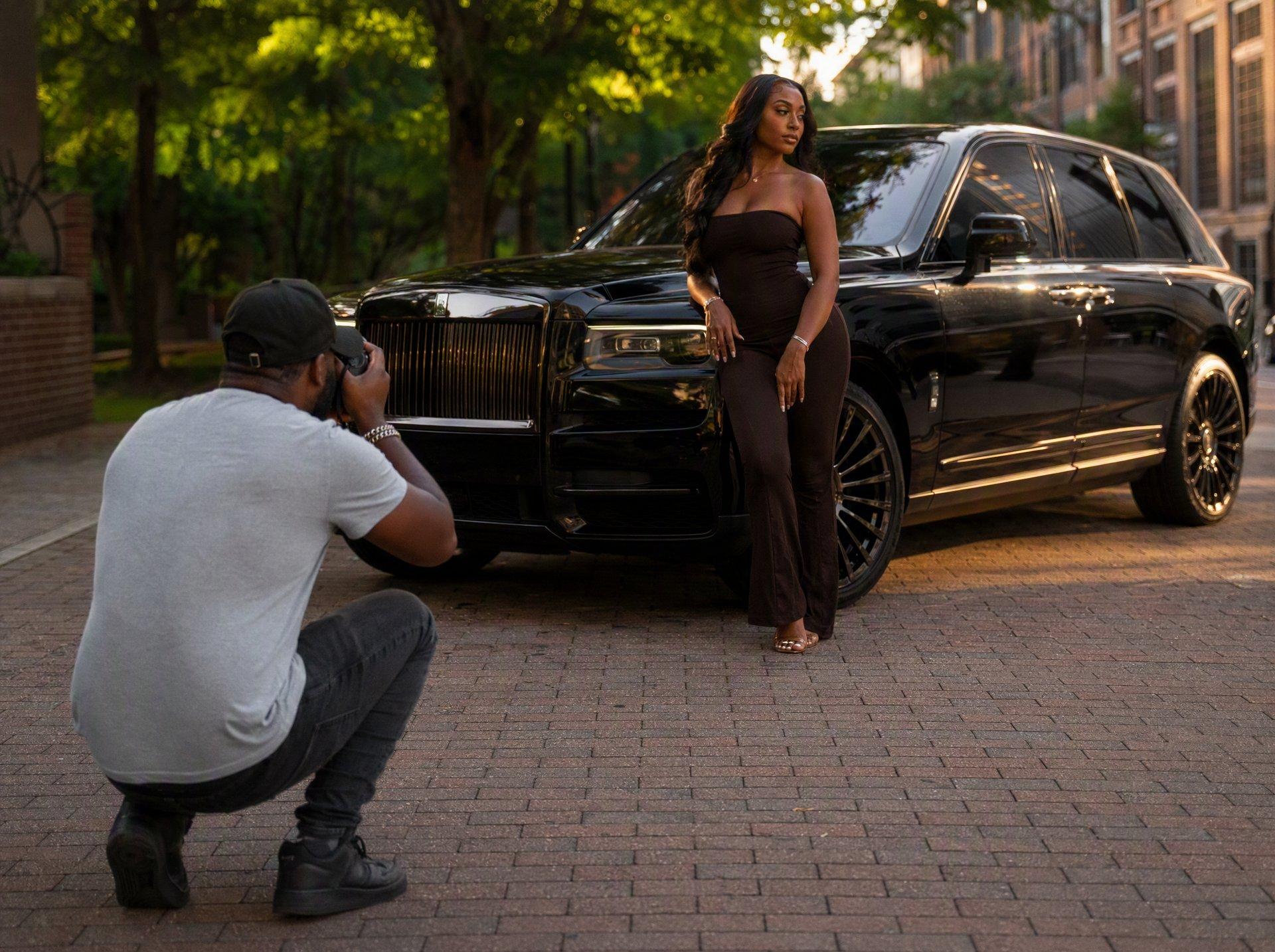 Photographer shooting a client beside a Rolls-Royce Cullinan in Atlanta
